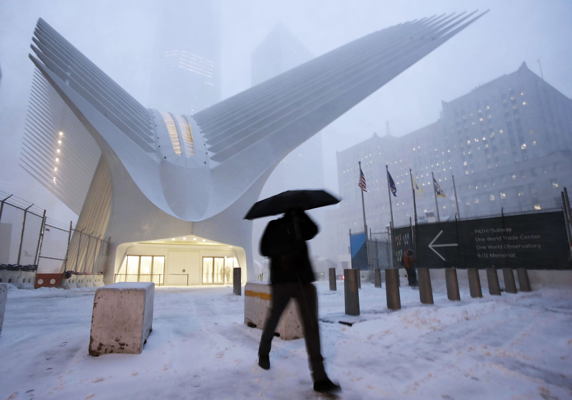 A man makes his way through wind and snow past the Oculus of the World Trade Center Transportation Hub, Thursday, Feb. 9, 2017, in New York. A powerful, fast-moving storm swept through the northeastern U.S. Thursday, making for a slippery morning commute and leaving some residents bracing for blizzard conditions.