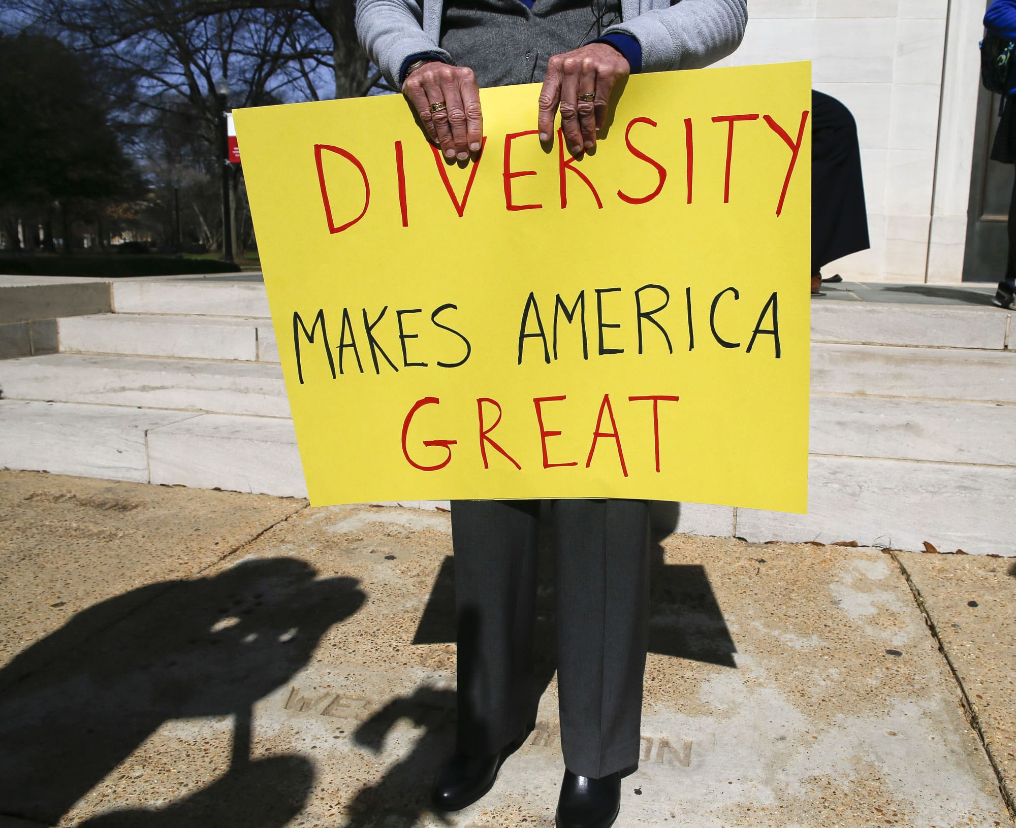 Professor Fran O'Neal holds a sign during a gathering at the University of Alabama in Tuscaloosa, Ala., to support an open campus and oppose the travel ban imposed by President Donald Trump Thursday, Feb.9, 2017.