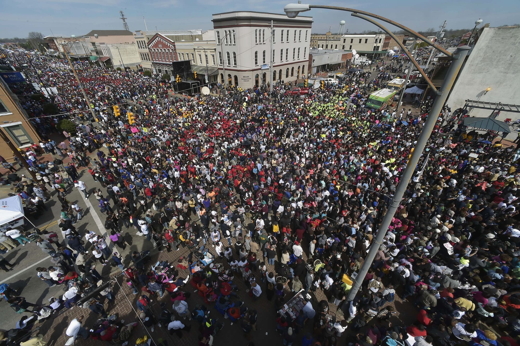 FILE- In this March 8, 2015, file photo, crowds gather before a symbolic walk across the Edmund Pettus Bridge in Selma, Ala. Organizers of the annual civil rights celebration and organizers of a Civil War battle re-enactment are upset the city is asking them to pay tens of thousands of dollars to cover the costs of police and fire protection and cleanup.