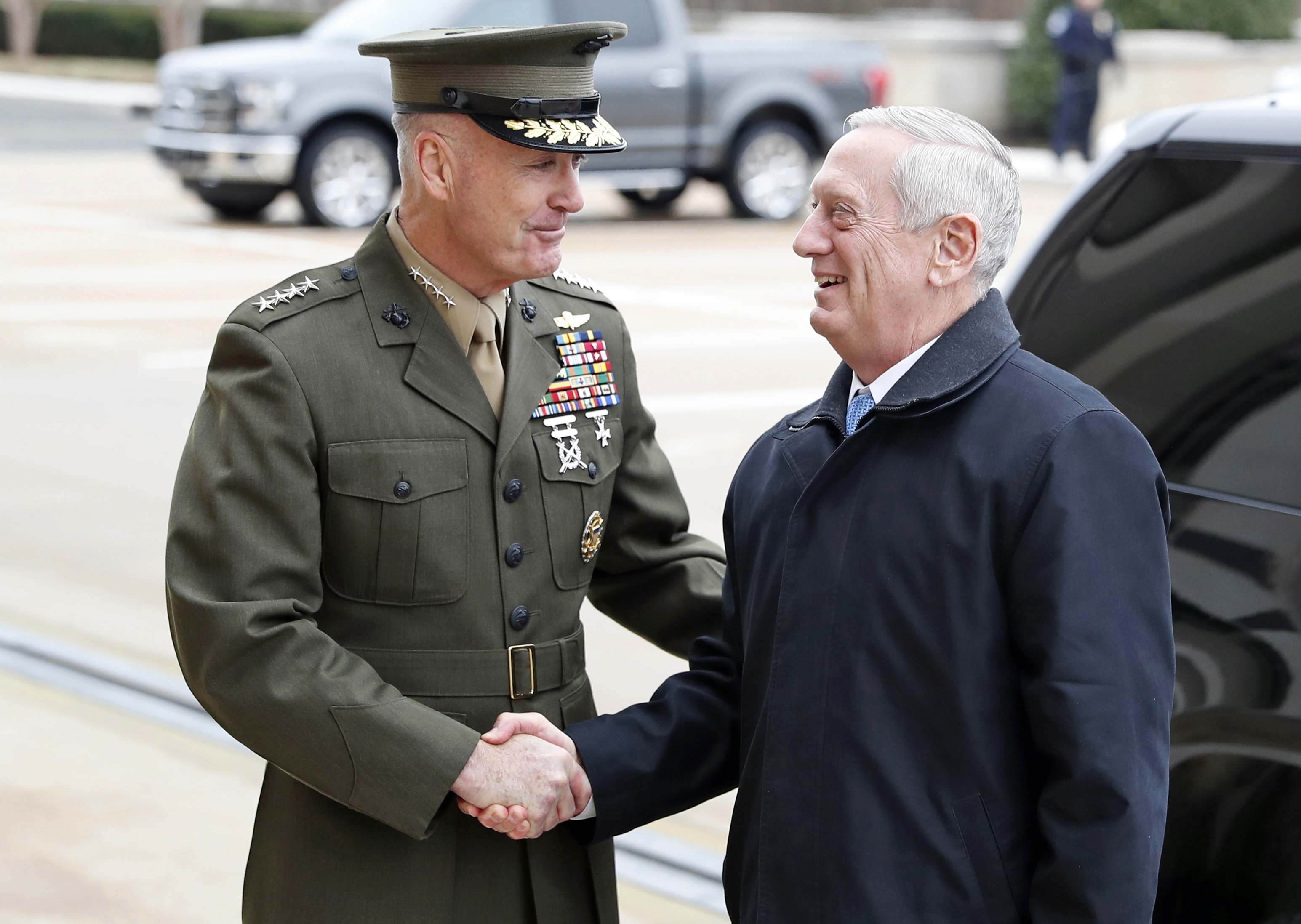 FILE - In this Jan. 21, 2107 file photo, Joint Chiefs Chairman Gen. Joseph Dunford greets Defense Secretary Jimn Mattis at the Pentagon. A new military strategy to meet President Donald Trump’s demand “to obliterate” the Islamic State group is likely to deepen U.S. military involvement in Syria, possibly with more ground troops, even as the current U.S. approach in Iraq appears to be working and will require fewer changes. Dunford said Feb. 23 that the strategy will take aim not just at the Islamic State but at al-Qaida and other extremist organizations in the Middle East and beyond whose goal is to attack the United States. He emphasized that it would not rest mainly on military might.