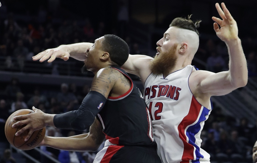 Detroit Pistons center Aron Baynes (12) reaches in on Portland Trail Blazers guard Damian Lillard (0) during the second half of an NBA basketball game, Tuesday, Feb. 28, 2017, in Auburn Hills, Mich.