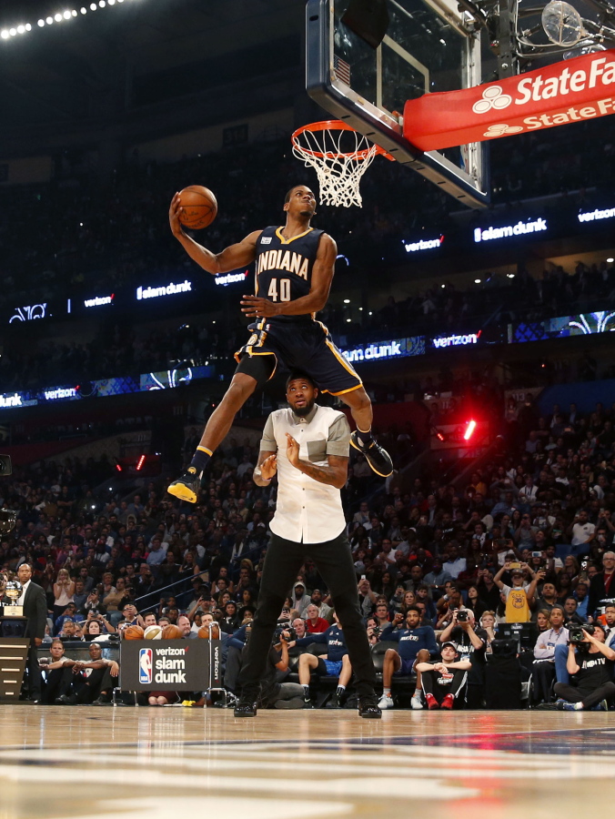 Indiana pacers Glenn Robinson III slam dunks over teammate Paul George as he participates in the slam dunk contest during NBA All-Star Saturday Night events in New Orleans, Saturday, Feb. 18, 2017.