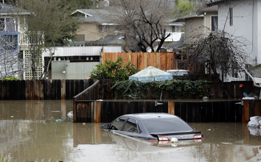 Cars and backyards are flooded in a neighborhood. Nearly half of California is under flood advisories.