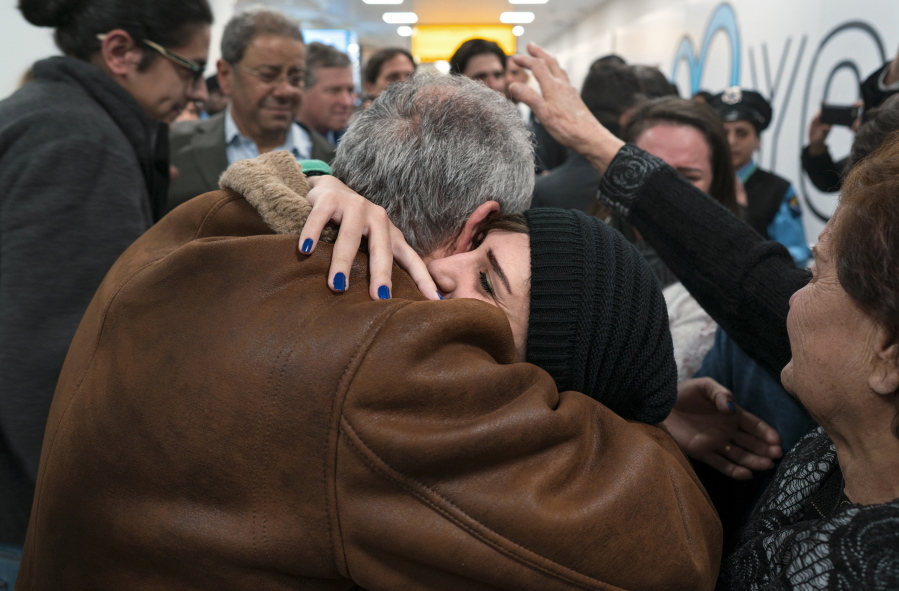 FILE - In a Monday, Feb. 6, 2017 file photo, family members who have just arrived from Syria embrace and are greeted by family who live in the United States upon their arrival at John F. Kennedy International Airport in New York. Organizers in cities across the U.S. are telling immigrants to miss class, miss work and not shop on Thursday, Feb. 16, 2017,  as a way to show the country how important they are to America&#039;s economy and way of life. &quot;A Day Without Immigrants&quot; actions are planned in cities including Philadelphia, Washington, Boston and Austin, Texas.
