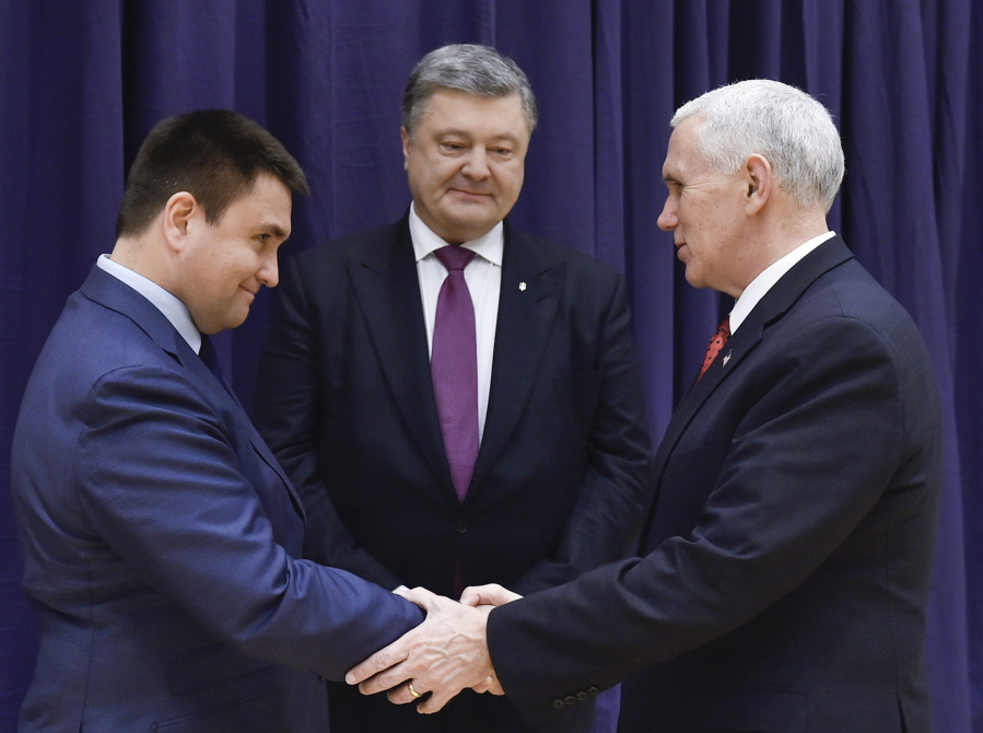 United States Vice President Mike Pence, right, shakes hands with Ukrainian Foreign Minister Pavlo Klimkin, left, as Ukraine&#039;s President Petro Poroshenko looks on, centre, during the Munich Security Conference in Munich, Germany, Saturday, Feb. 18, 2017.  America&#039;s commitment to NATO is &quot;unwavering,&quot; Pence said Saturday, reassuring allies about the direction the Trump administration might take but leaving open questions about where Washington saw its relationship with the European Union and other international organizations.