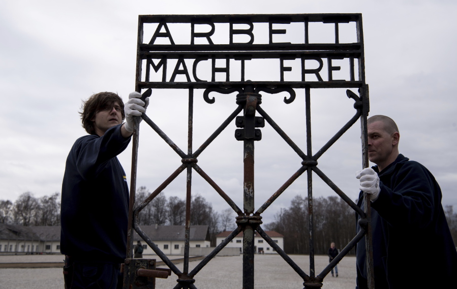 Employees of a transport company carry the gate with the writing &quot;Arbeit macht frei&quot; (Work Sets you Free) at the memorial of the former  Nazi concentration camp in Dachau, Germany, on Wednesday. The gate was stolen in 2014 and reappeared in November near the city of Bergen in Norway.