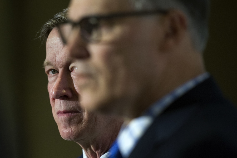 Colorado Gov. John Hickenlooper, left, looks at Washington Gov. Jay Inslee during a Democratic Governors Association  news conference following a DGA meeting at the National Governors Association Winter Meeting in Washington on Saturday.