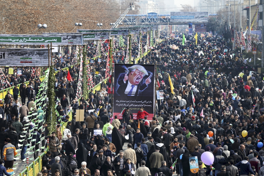 Iranians carry a placard with a caricature of President Donald Trump on Friday in Tehran, Iran, during a rally commemorating the anniversary of the 1979 Islamic Revolution.