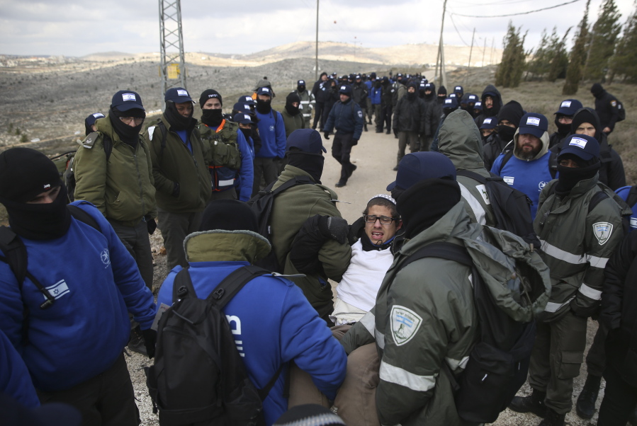 Israeli police arrest a settler Wednesday during the evacuation of the West Bank outpost of Amona.