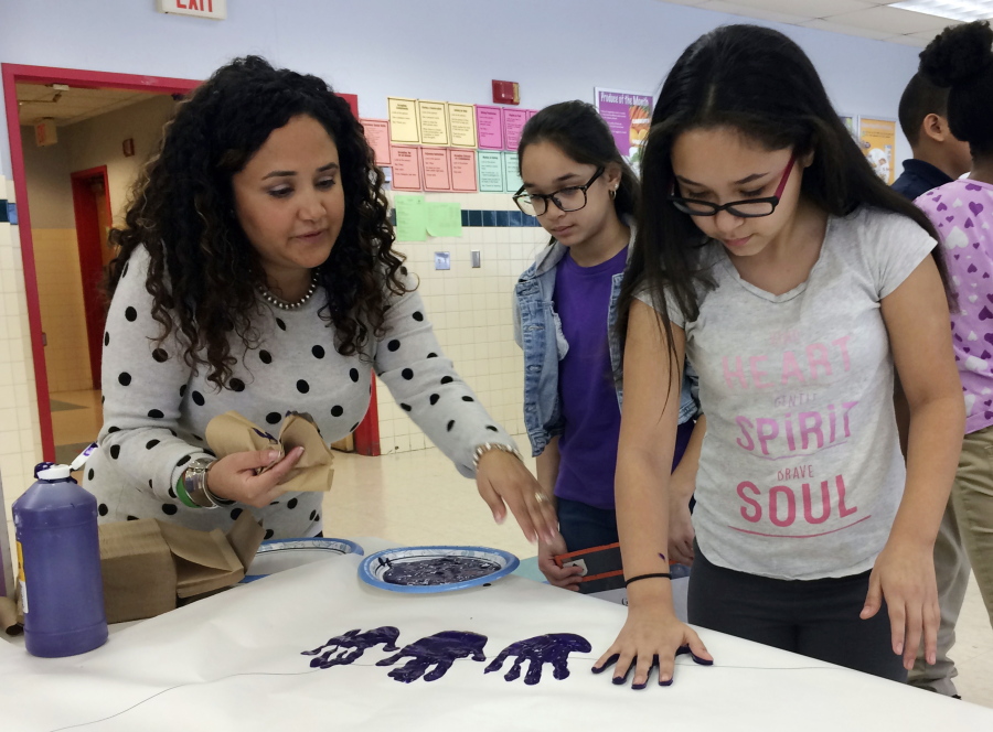 Nelba Marquez-Greene helps 10-year-old Araceli Buchko put her hand print inside a giant paper heart as part of the Love Win&#039;s campaign&#039;s Friendship Day, a social and emotional learning activity at the Chamberlain Elementary School in New Britain, Conn.