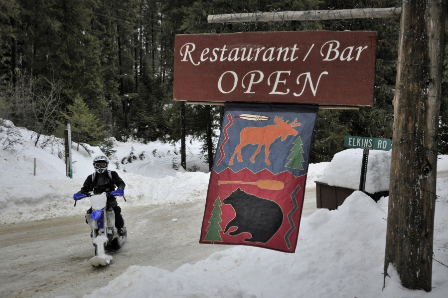 A snow machine rider passes a restaurant at Priest Lake, Idaho, on Feb. 10. Relentless snowfall has smothered Priest Lake this winter, and snowmobilers are loving it.
