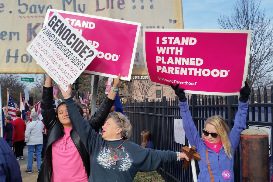 A Planned Parenthood supporter and opponent try to block each other&#039;s signs during a protest and counter-protest Saturday in St. Louis.