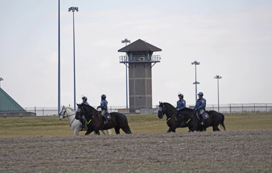 Mounted police patrol travel along Smyrna Landing Road alongside James T. Vaugh Corrections center Thursday in Smyrna, Del. Inmates used &quot;sharp instruments&quot; to take control of the building on Wednesday.