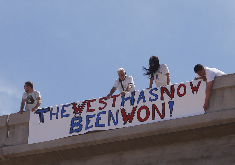 Supporters of the Bundy family hang a sign April 12, 2014 on the Interstate 15 highway overpass just outside of Bunkerville, Nev., after the Bureau of Land Management agreed to release the impounded cattle. A federal agent testified in Las Vegas, Nev., Wednesday, Feb. 15, 2017, that he saw a &quot;sniper&quot; on a freeway overpass pointing a military-style weapon at him while a crowd of protesters gathered in a dry river bed calling for the government to release Nevada rancher Cliven Bundy&#039;s cattle.