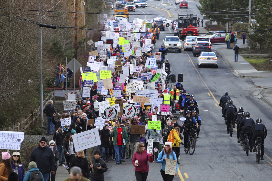 Protesters march up a hill to the office of Rep. Dave Reichert, R-Wash., on Thursday in Issaquah. They were angry that he refused to hold a town hall meeting.