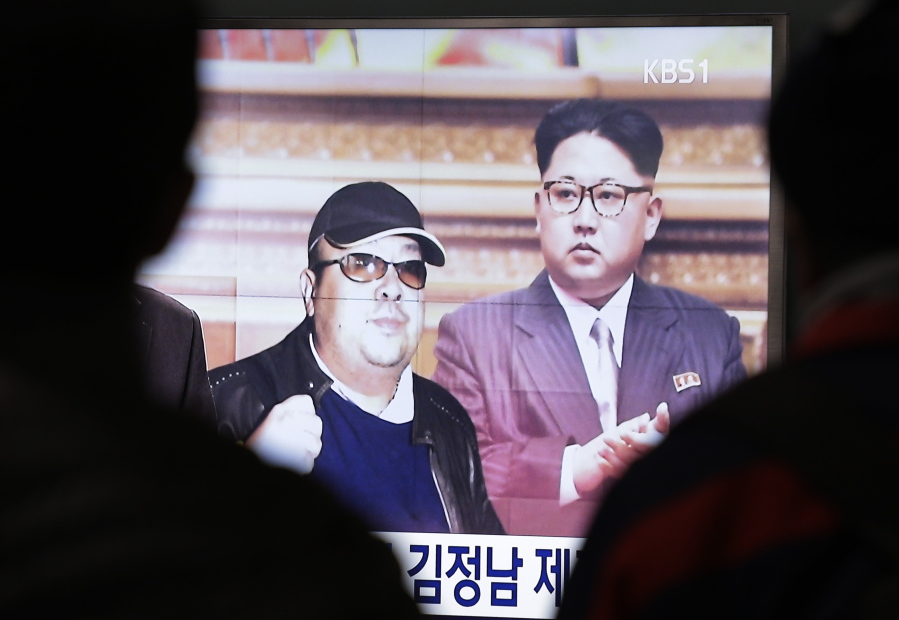 A TV screen at a railway station in Seoul, South Korea, shows file photos Tuesday of North Korean leader Kim Jong Un and his older brother Kim Jong Nam, left.