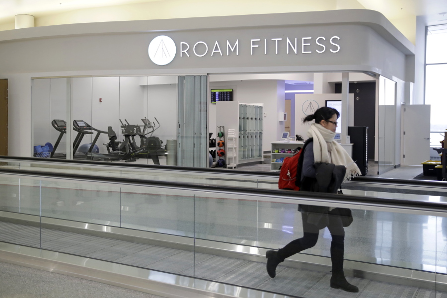 In this Jan. 30, 2017 photo, a traveler walks past the soon-to-be-open ROAM Fitness gym at Baltimore-Washington International Thurgood Marshall Airport in Linthicum, Md. Working out while waiting for your flight will soon be an option at BWI, where the only gym at a U.S. airport past security will open this week, with plans for 20 more at airports by 2020.