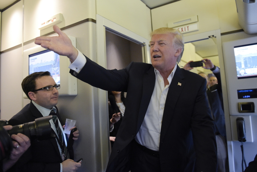 President Donald Trump talks to reporters on board Air Force One as he arrived to speak at his &quot;Make America Great Again Rally&quot; at Orlando-Melbourne International Airport in Melbourne, Fla., on Saturday.