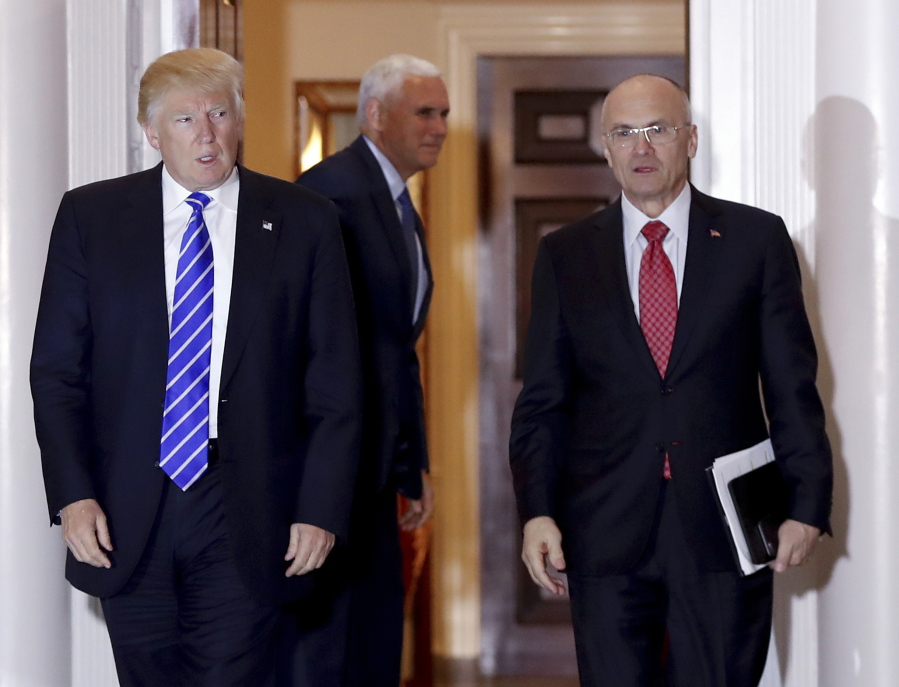 Then-President-elect Donald Trump walks Labor Secretary-designate Andrew Puzder from Trump National Golf Club Bedminster clubhouse in Bedminster, N.J. Puzder has proposed avoiding conflicts of interest by resigning as CEO of his fast food empire, selling off hundreds of holdings and recusing himself from government decisions in which he has a financial interest, according to his ethics filings with the government.