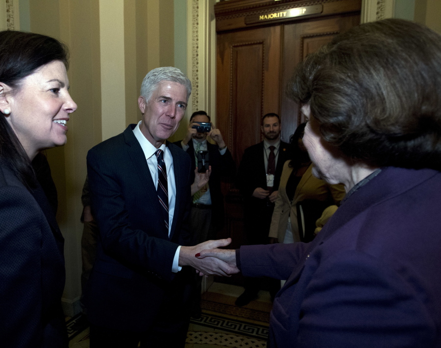 Supreme Court nominee Neil Gorsuch, accompanied by former New Hampshire Sen. Kelly Ayotte, left, shakes hands Wednesday with Sen. Dianne Feinstein, D-Calif., the ranking member of the Senate Judiciary Committee.