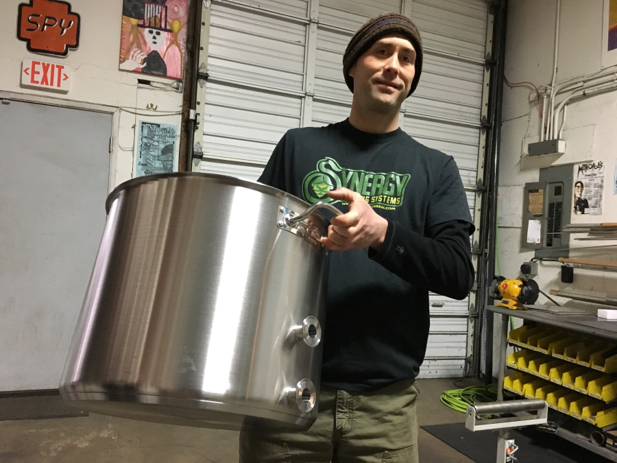 Aaron Keeney, founder and co-owner of Synergy Brewing Systems, holds a stainless steel brewing kettle early this month in Eugene, Ore. The company produces high-end home brewing systems, used by home brewers and start-up commercial brewers.