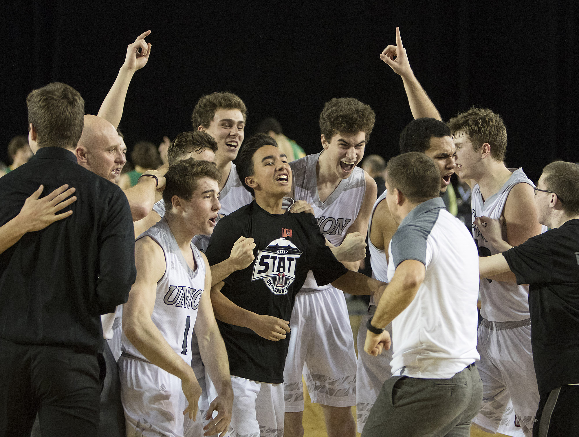 Union's players and coaches react after defeating Richland Friday, March 3, 2017, during the semifinals of the 4A Boys State Basketball Tournament in Tacoma, Wash. Union bested Richland 63-61 to advance to the championship game.