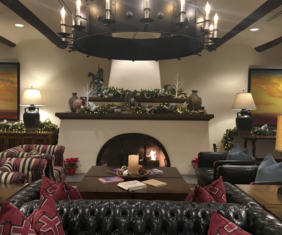 The Wigwam Resort&#039;s main lobby invites visitors to sink into a cozy spot by the fire.