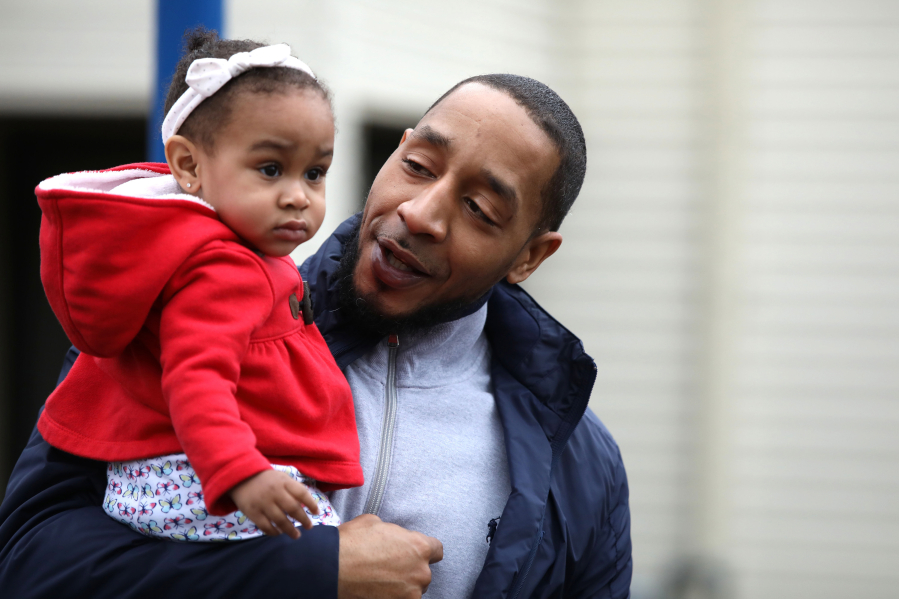 Terrill Swift walks to the park with his 1-year-old daughter, Aria Swift, on Tuesday in Lisle, Ill. Swift was exonerated for a murder and sexual assault he did not commit, yet his mugshot continues to appear on several websites portraying him as a criminal.