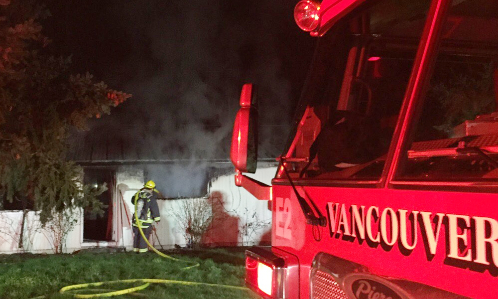 A firefighter extinguishes a blaze early Friday morning in Vancouver's Hough neighborhood. The fire damaged one half of a duplex on West 24th Street. No injuries were reported.