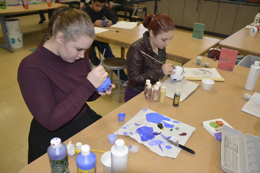 Washougal: Through a Washougal Schools Foundation mini grant, advanced arts students, such as Haleigh Metz, left, and Tianna Godin, made Zulu Coconuts by painting coconut shells that came in from Florida.