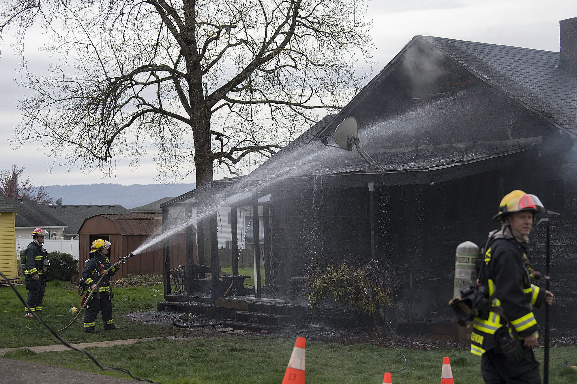 Firefighters work to extinguish a house fire on West 36th Street on Tuesday afternoon, March 28, 2017.