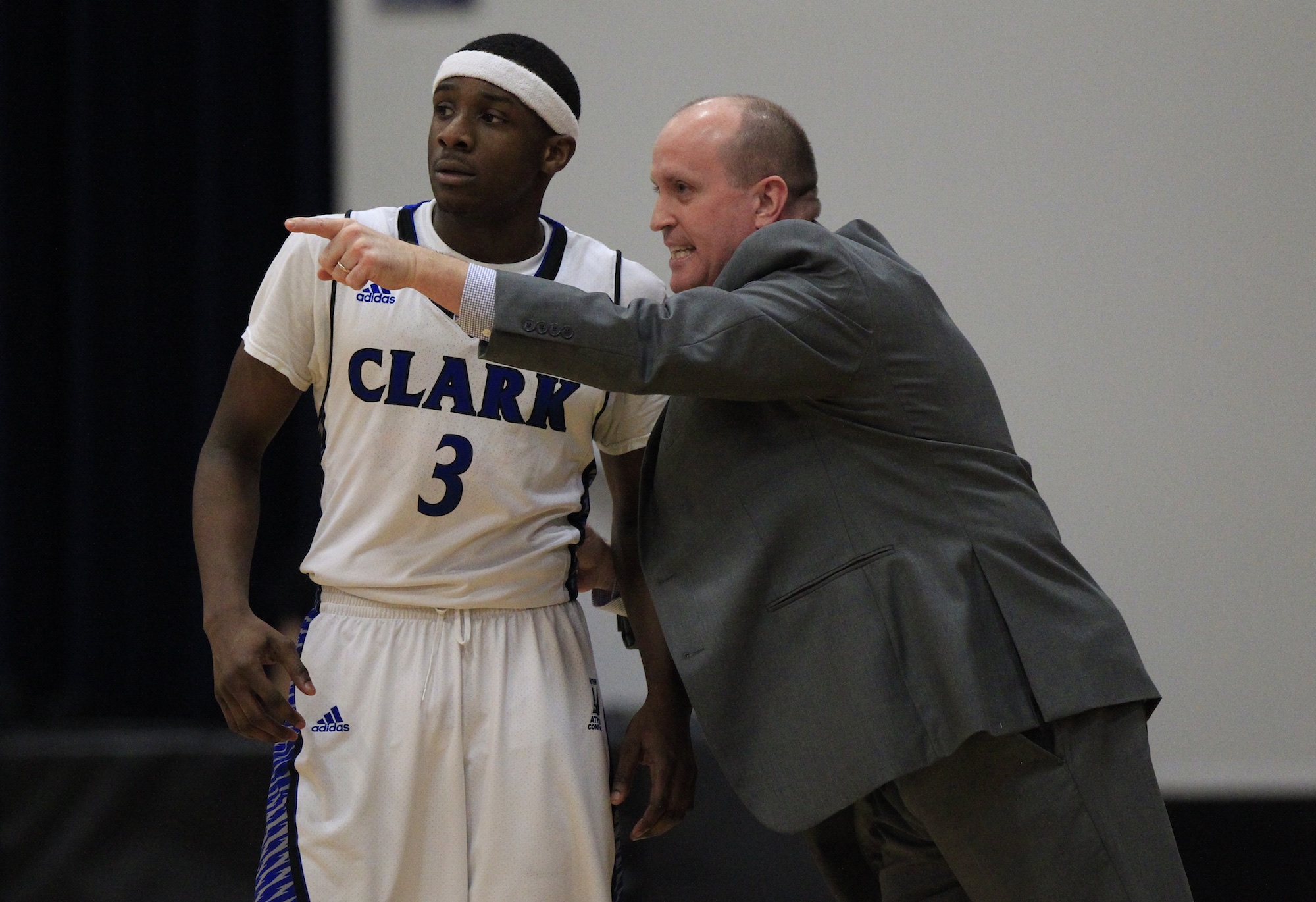 Clark College basketball interim head coach Kevin Johnson gives instructions to Surmon Neal.