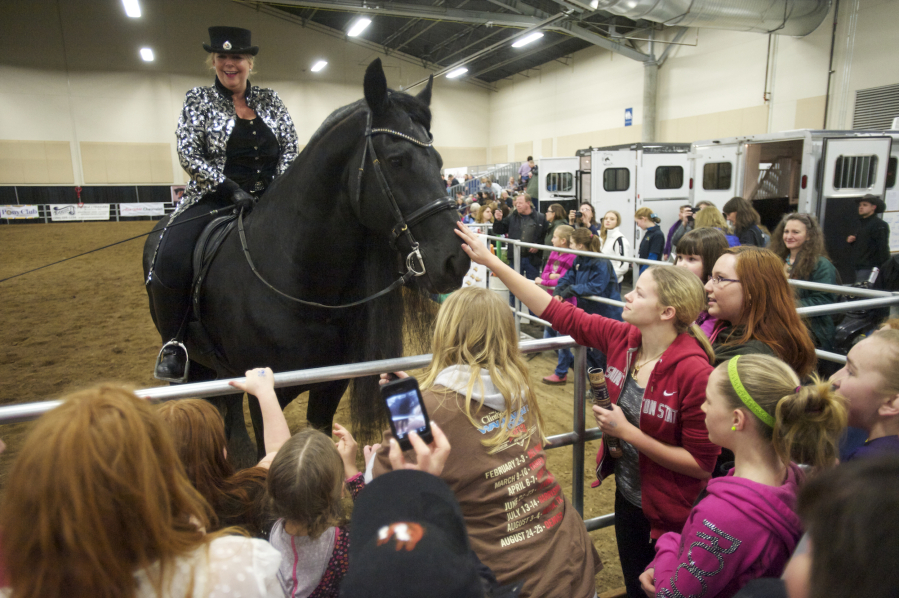 Susan McIntosh and Sir Ruben, a 17-year-old Star Stallion, say hello to spectators after the BlackPearl Friesian Dance Troupe performance at the Washington State Horse Expo held at the Clark County Event Center at the Fairgrounds in February 2014. The 2017 expo begins today.