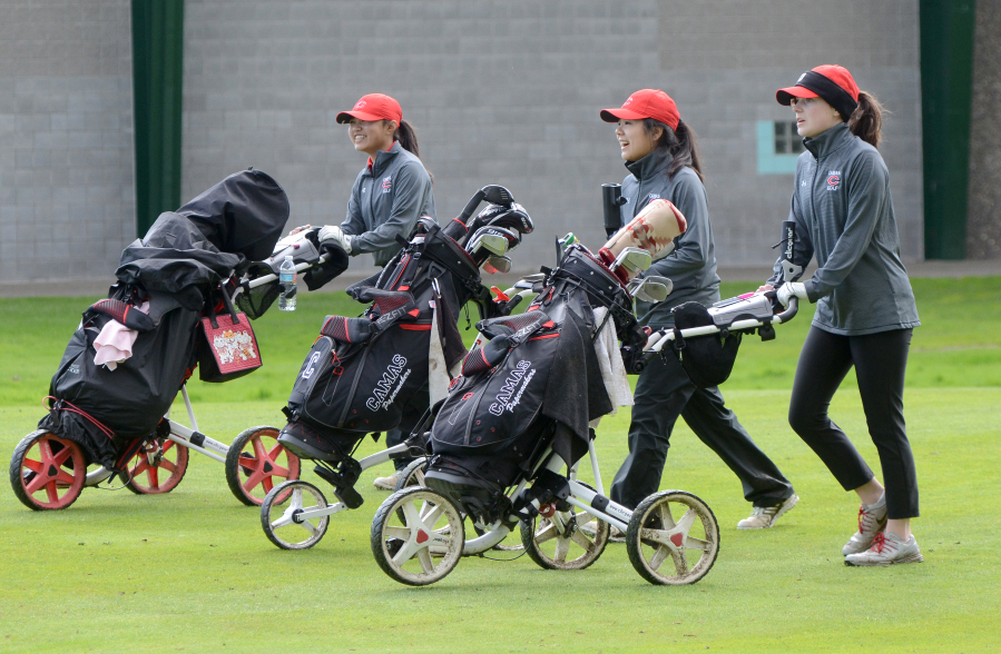 Camas golfers Lauryn Tsukimura, left, Abby Jiang, and Emma Cox walk down the first fairway at Club Green Meadows on Thursday, March 30, 2017.