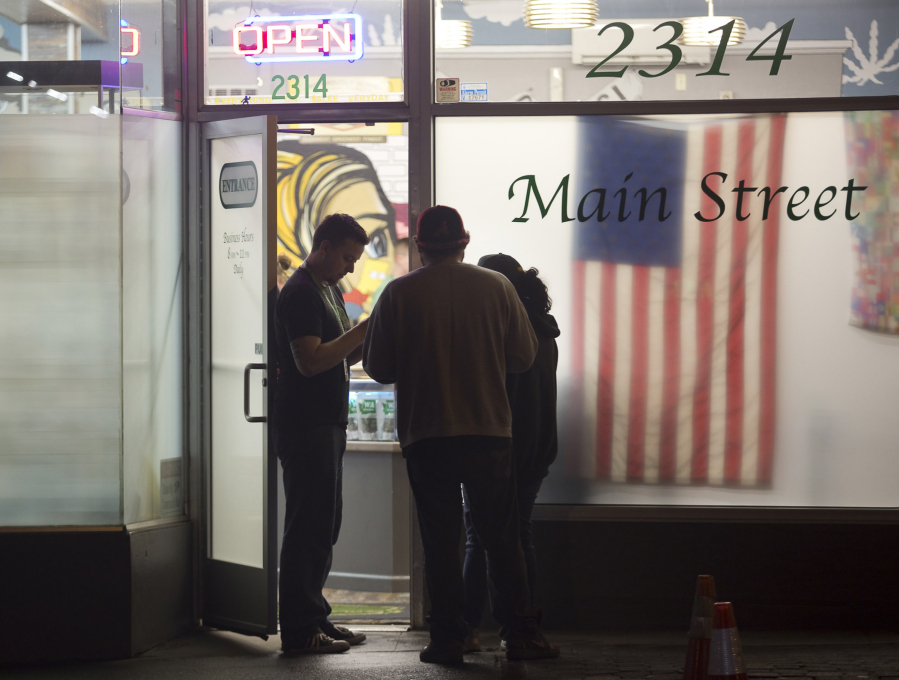 A security guard checks customers&#039; identification as they shop at Main Street Marijuana after 10 p.m. on a recent night. Nearby residents say the late-night customers at the popular shop disrupt their evenings with noise and traffic.