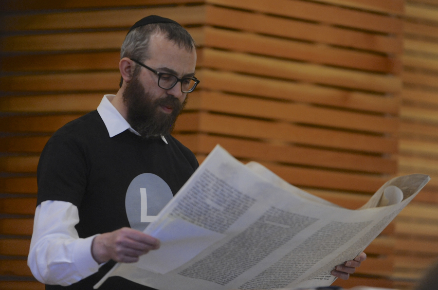 Rabbi Shmulik Greenberg reads the Megillah, or the story of the Book of Esther, at the Purim holiday celebration.