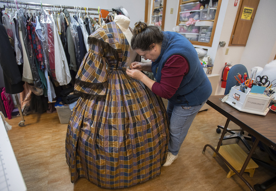 Eileen Trestain, seamstress and wardrobe department manager for Fort Vancouver National Historic Site, works on a silk dress from about 1855.