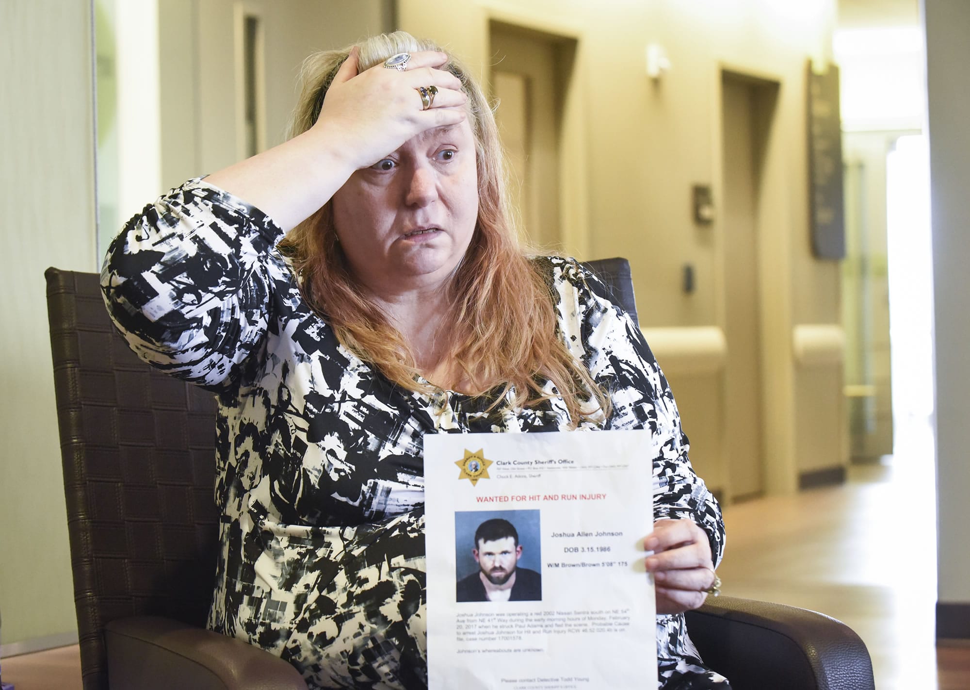 Nancy Peterson, mother of Paul Adams, who has been hospitalized since Feb. 20 when he was struck while walking along the road in Vancouver’s Truman neighborhood, holds a wanted persons poster for Joshua Johnson, the driver suspected in the crash, Friday, March 24, 2017, at PeaceHealth Southwest Medical Center in Vancouver.