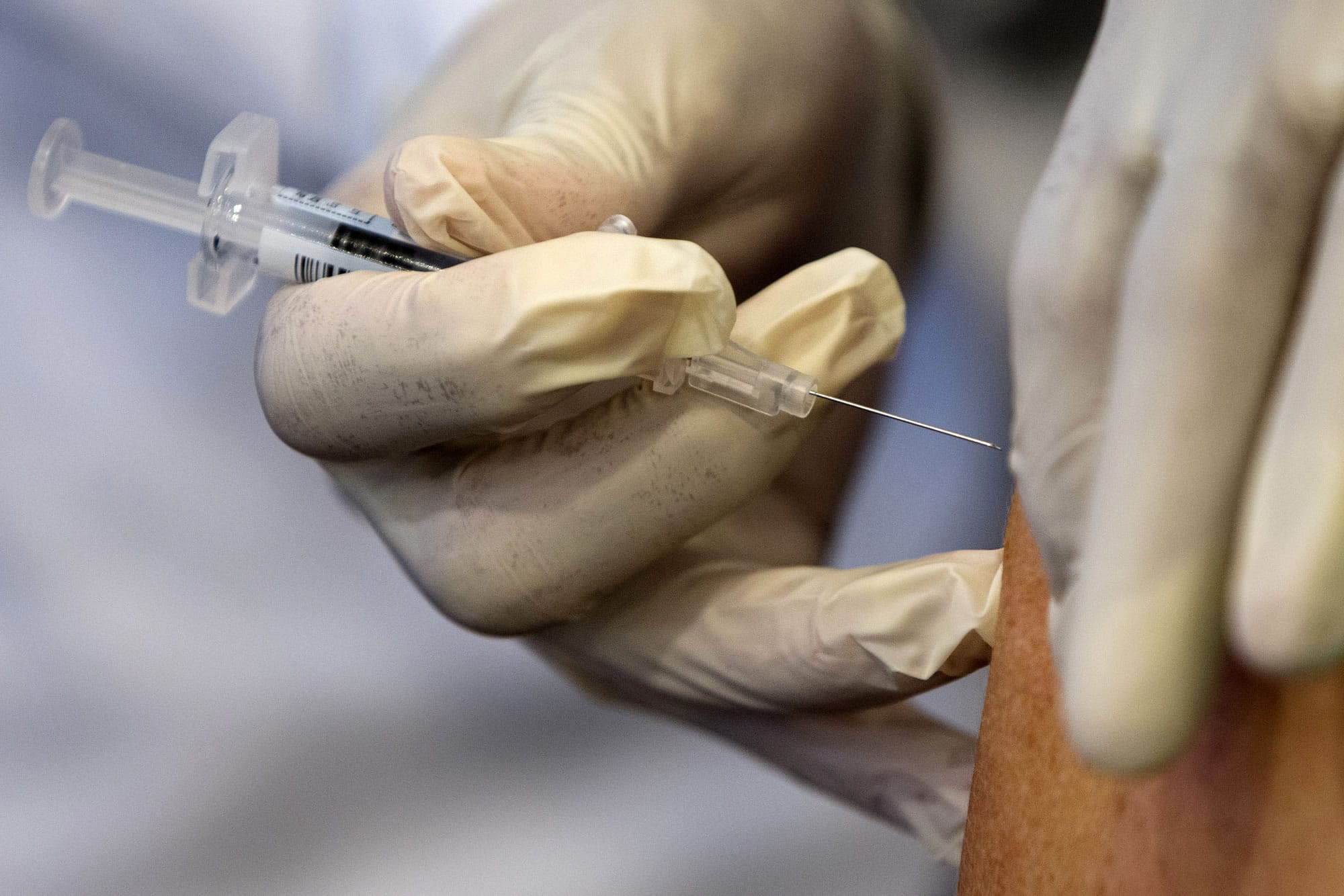 A nurse administers a flu vaccine shot in Washington. Medical expenses are a burden whenever they hit, but a recent study found they’re most common around the first few months of the year.