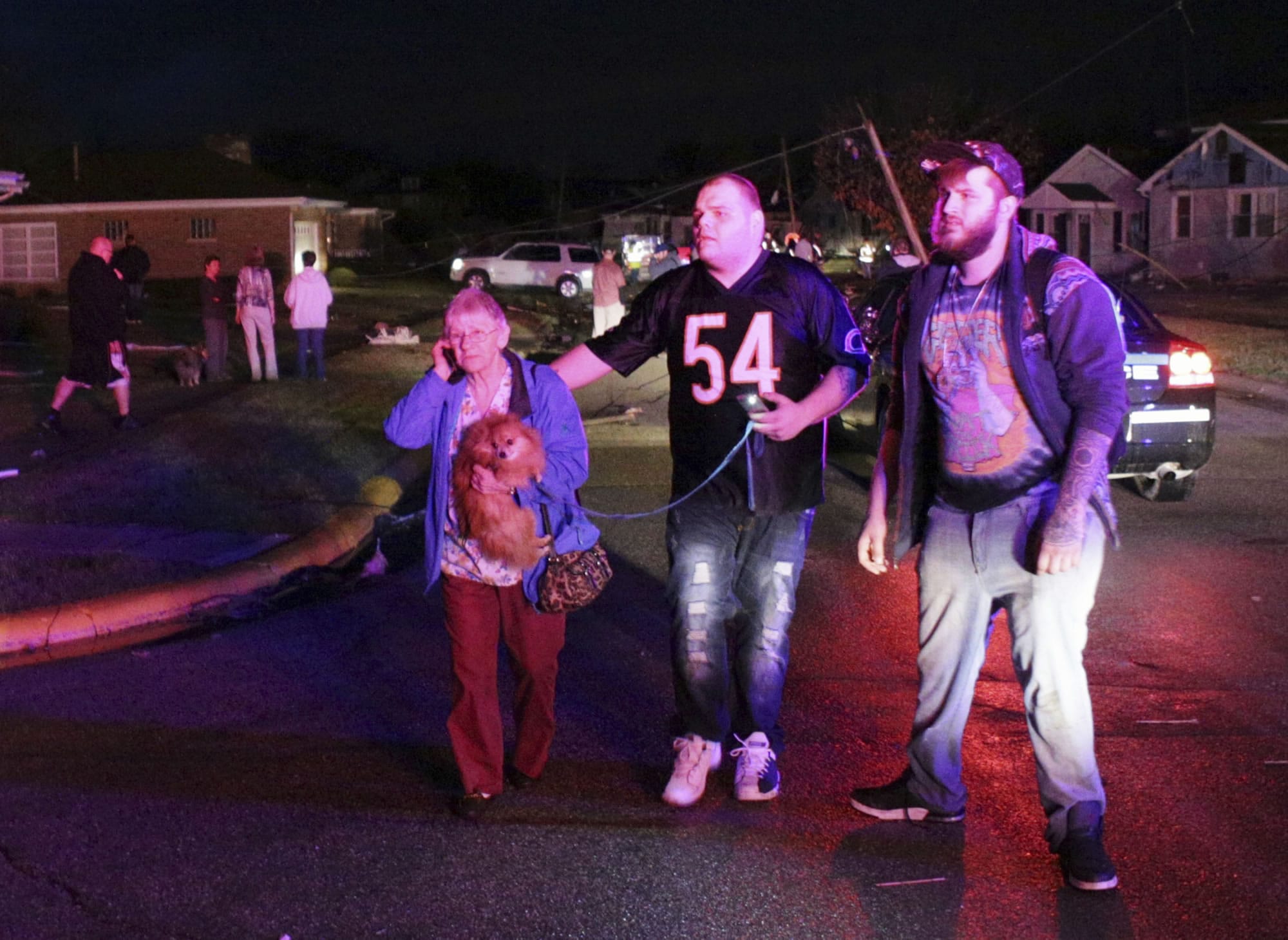 Jeremy Gossett, right, and Mathew McBee, center, help escort a woman and her dog to a fire truck following a tornado in Naplate, Ill., Tuesday, Feb. 28, 2017. Tornadoes touched down in the upper Midwest and northern Arkansas on Tuesday.