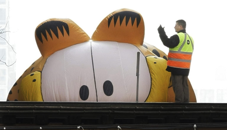 FILE - In this Nov. 27, 2008, file photo, the Garfield the Cat helium balloon appears to be peering at a Chicago Transit Authority worker on the elevated tracks inside Chicago's famed Loop during the Thanksgiving Day Parade in Chicago. Garfield creator Jim Davis sought to quell a controversy over the cat's gender by telling The Washington Post on Feb. 28, 2017, that the cat is male.