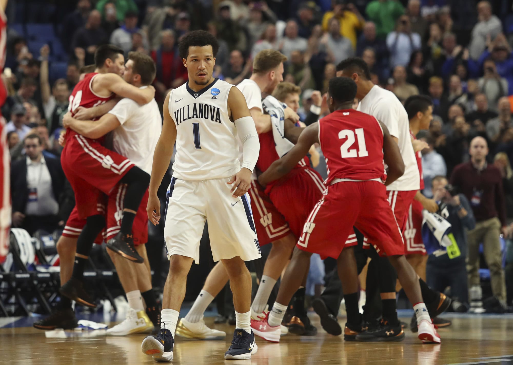 Villanova guard Jalen Brunson (1) leaves the court as Wisconsin players celebrate the end of their second-round game in the men's NCAA college basketball tournament, Saturday, March 18, 2017, in Buffalo, N.Y. Wisconsin won 65-62.