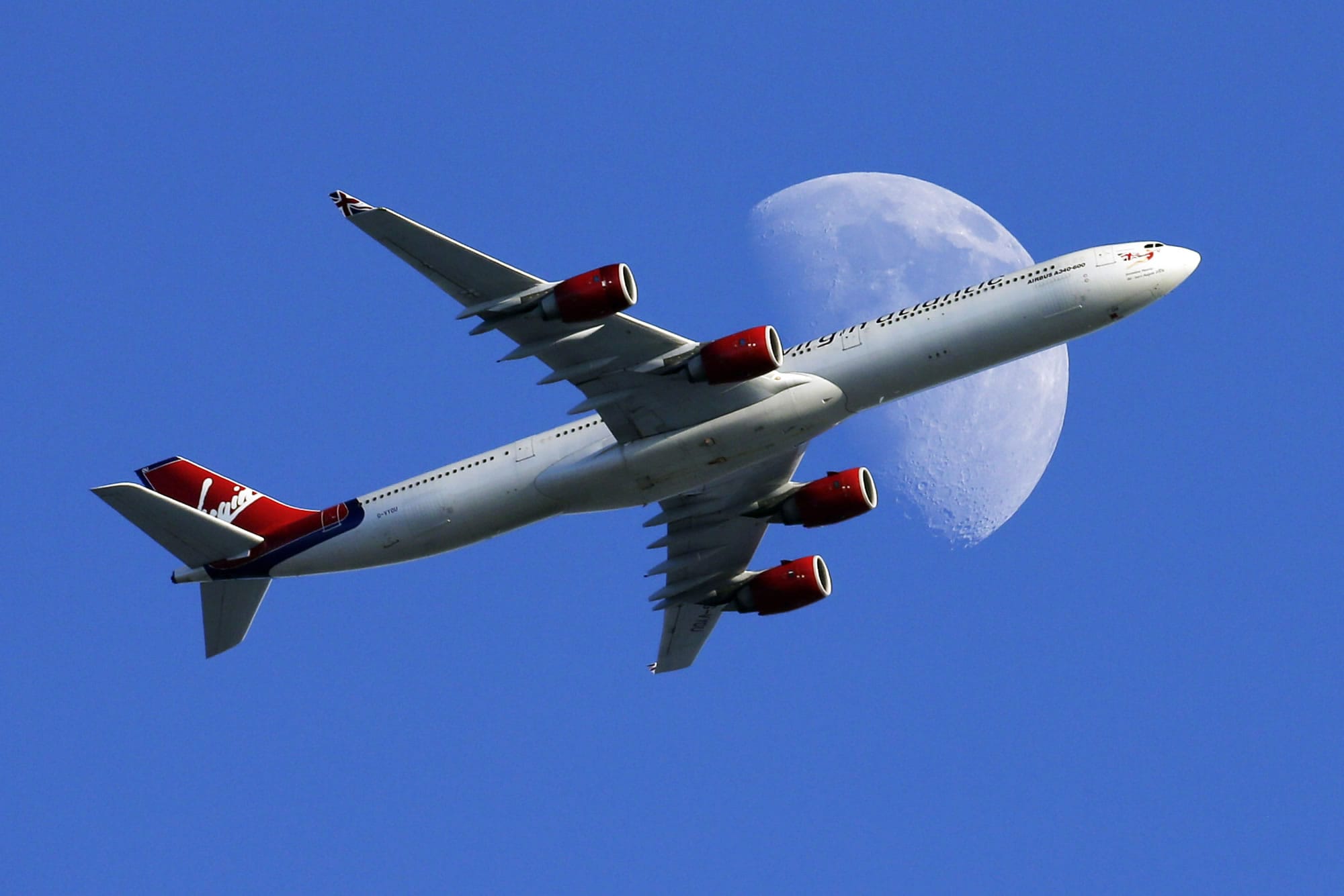 FILE - In this Sunday, Aug. 23, 2015, file photo, a Virgin Atlantic passenger plane crosses a waxing gibbous moon on its way to the Los Angeles International Airport, in Whittier, Calif. Alaska said Wednesday, March 22, 2017, that it will retire the Virgin brand, probably in 2019. Alaska announced in 2016, that it was buying Virgin, but CEO Brad Tilden held out hope to Virgin fans that he might keep the Virgin America brand, and run it and Alaska as separate airlines under the same corporate umbrella.