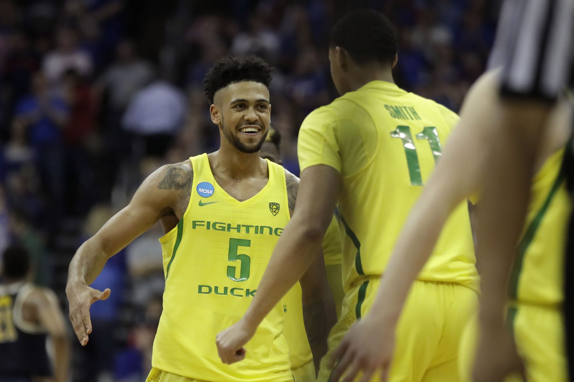 Oregon guard Tyler Dorsey (5) celebrates with Keith Smith (11) at the end of a regional semifinal against Michigan in the NCAA men's college basketball tournament, Thursday, March 23, 2017, in Kansas City, Mo. Oregon won 69-68.