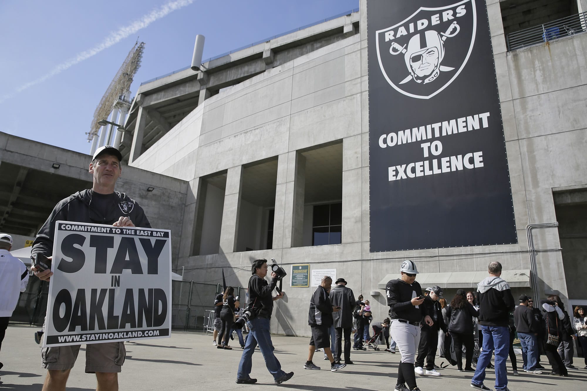 John P. Kelleher holds up a sign outside the Oakland Coliseum before the start of a rally to keep the Oakland Raiders from moving Saturday, March 25, 2017, in Oakland, Calif. NFL owners are expected to vote on the team's possible relocation to Las Vegas on Monday or Tuesday at their meeting in Phoenix.
