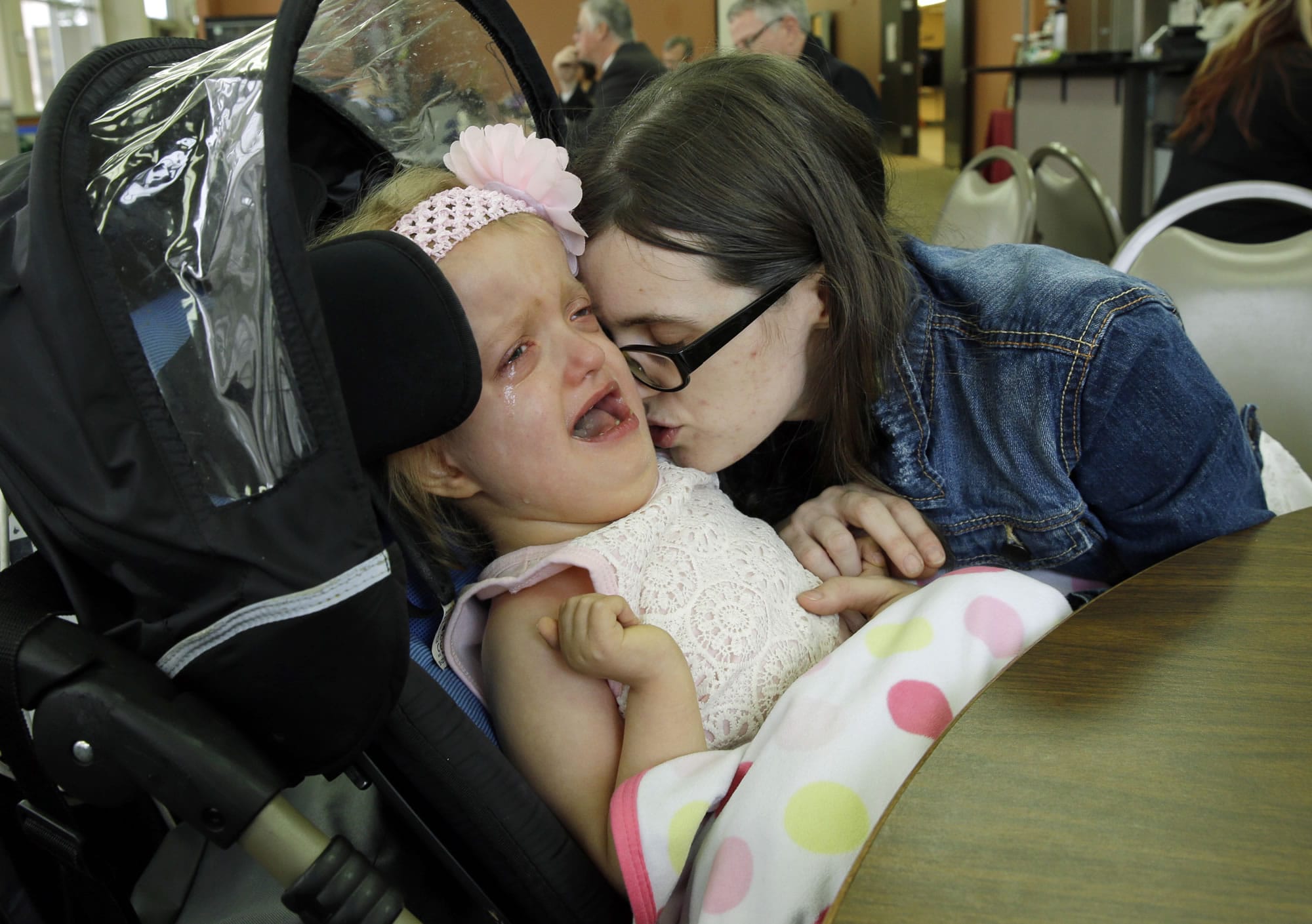In this Tuesday, March 28, 2017 photo, Meagan Holt comforts her daughter Maddie after they attended a hearing at the Capitol in Olympia, Wash., for House Bill 1060, which would allow parents or guardians to administer medical marijuana to children while at school or on a school bus. Maddie has a terminal genetic disease called Zellweger Syndrome, and used to have hour-long seizures, but Holt says that Maddie has found relief after treatment with cannabis oil and other pharmaceuticals. (AP Photo/Ted S.