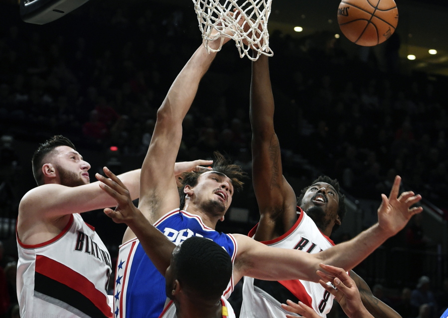 Portland Trail Blazers center Jusuf Nurkic. top left, blocks the shot of Philadelphia 76ers forward Dario Saric, top center, as Trail Blazers forward Al-Farouq Aminu, top right, closes in during the first half of an NBA basketball game in Portland, Ore., Thursday, March 9, 2017.