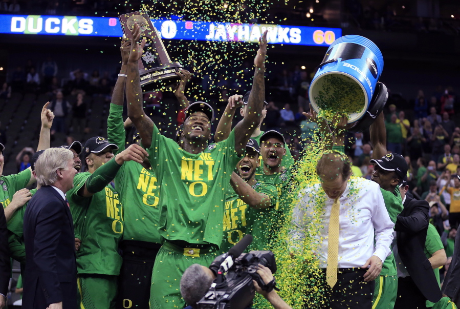 Oregon players celebrate with coach Dana Altman after a Midwest Regional final against Kansas in the NCAA men&#039;s college basketball tournament, Saturday, March 25, 2017, in Kansas City, Mo. Oregon won 74-60.