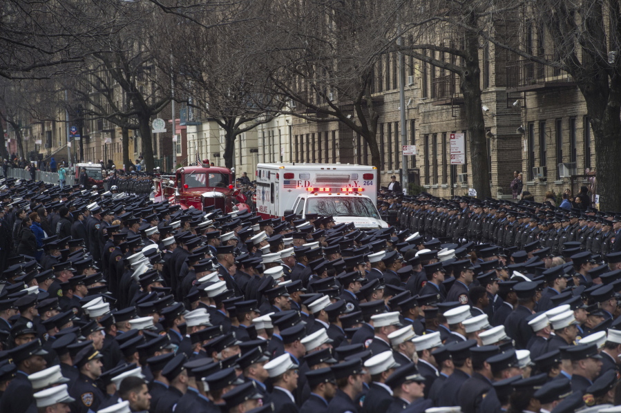 Hundreds of uniformed firefighters fill the street Saturday as an ambulance carrying the body of fallen New York Fire Department emergency medic Yadira Arroyo proceeds toward St. Nicholas of Tolentine Church in the Bronx borough of New York.