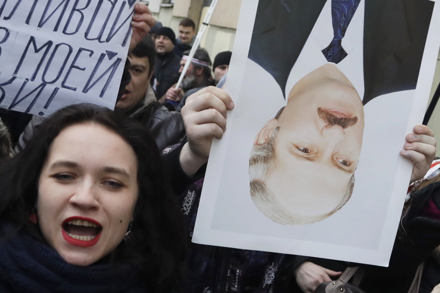 A protester holds an upside-down portrait of President Alexander Lukashenko during a rally March 15 in Minsk, Belarus.